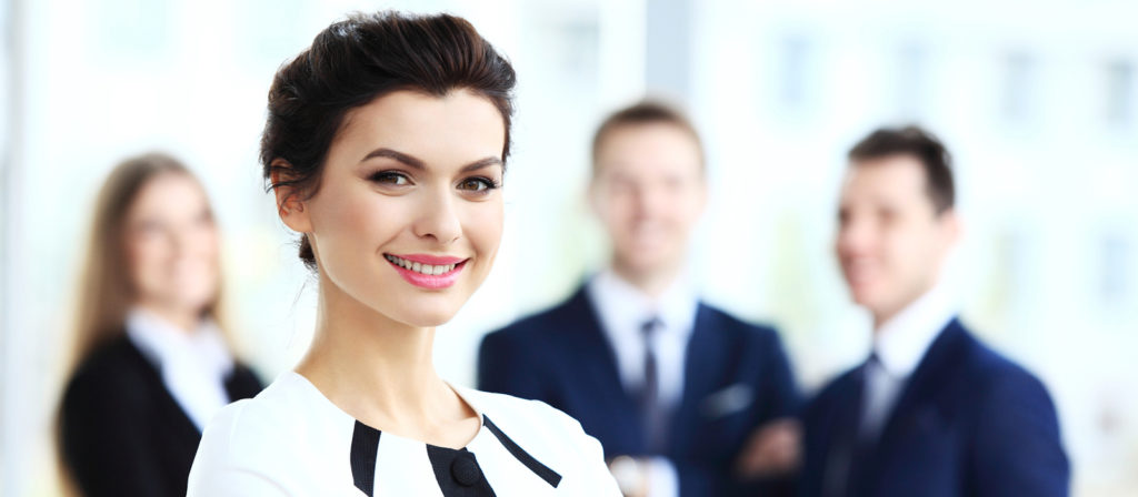 portrait photo professionnel d'une femme cadre souriante posant devant ses collègues de travail