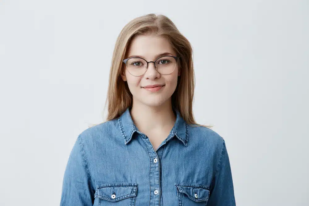 photo portrait professionnel d'une jeune femme en chemise bleue avec des lunettes